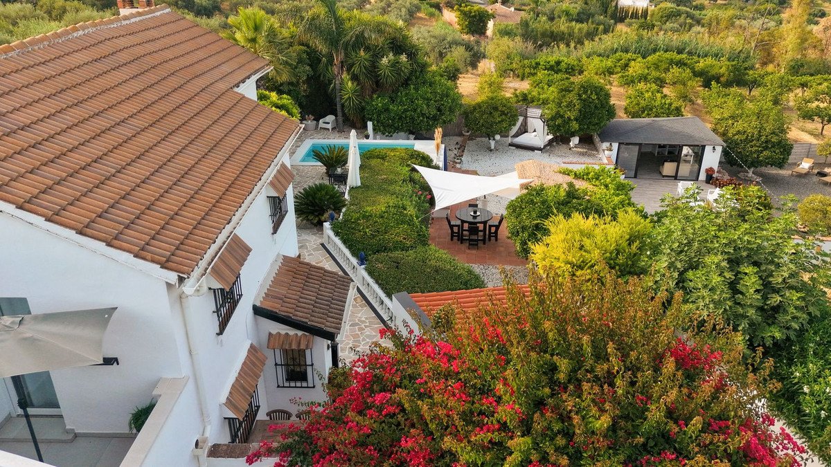 Luxurious white house with terracotta roof, swimming pool, and lush garden