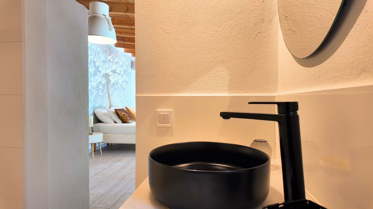 Modern bathroom featuring a black soaking tub and a round mirror