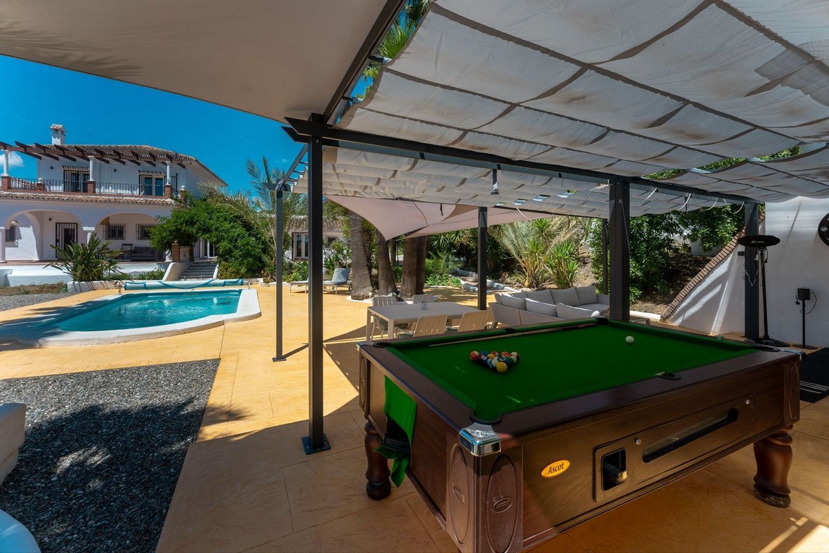 Outdoor pool area with patio, table tennis, and lounge chairs under a canopy