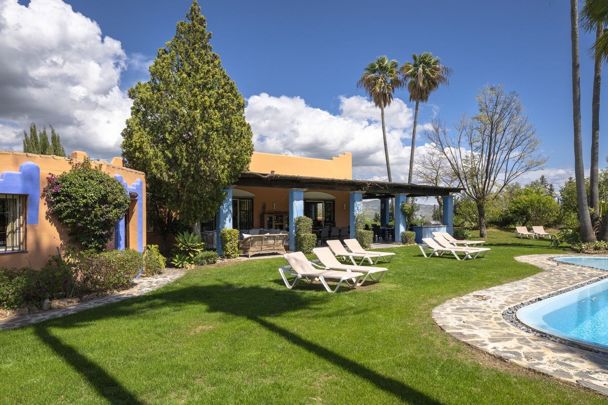 Luxurious outdoor swimming pool with lounge chairs and a covered patio area