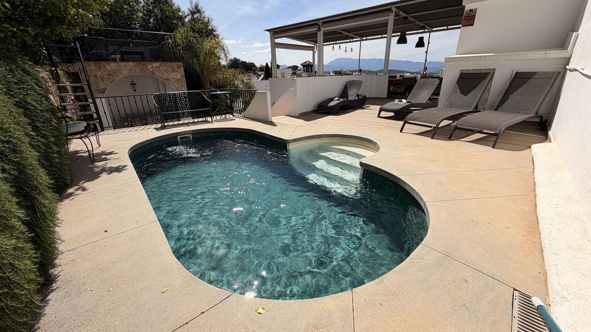 Private pool with lounge chairs, covered patio, and mountain views.