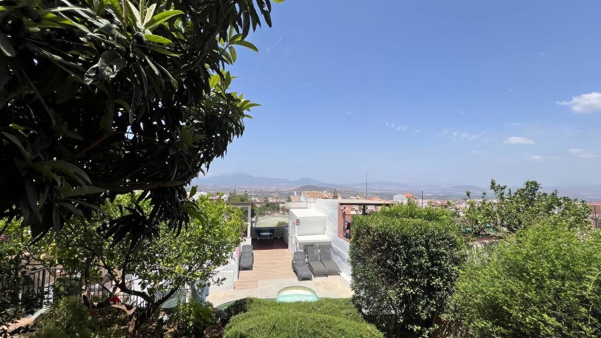 Rooftop terrace with lounge chairs, small pool, and panoramic mountain views under a clear blue sky.