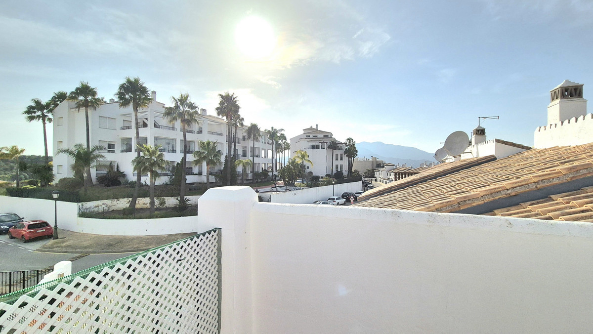 Uitzicht vanaf het terras op een Marbella pand met palmbomen.