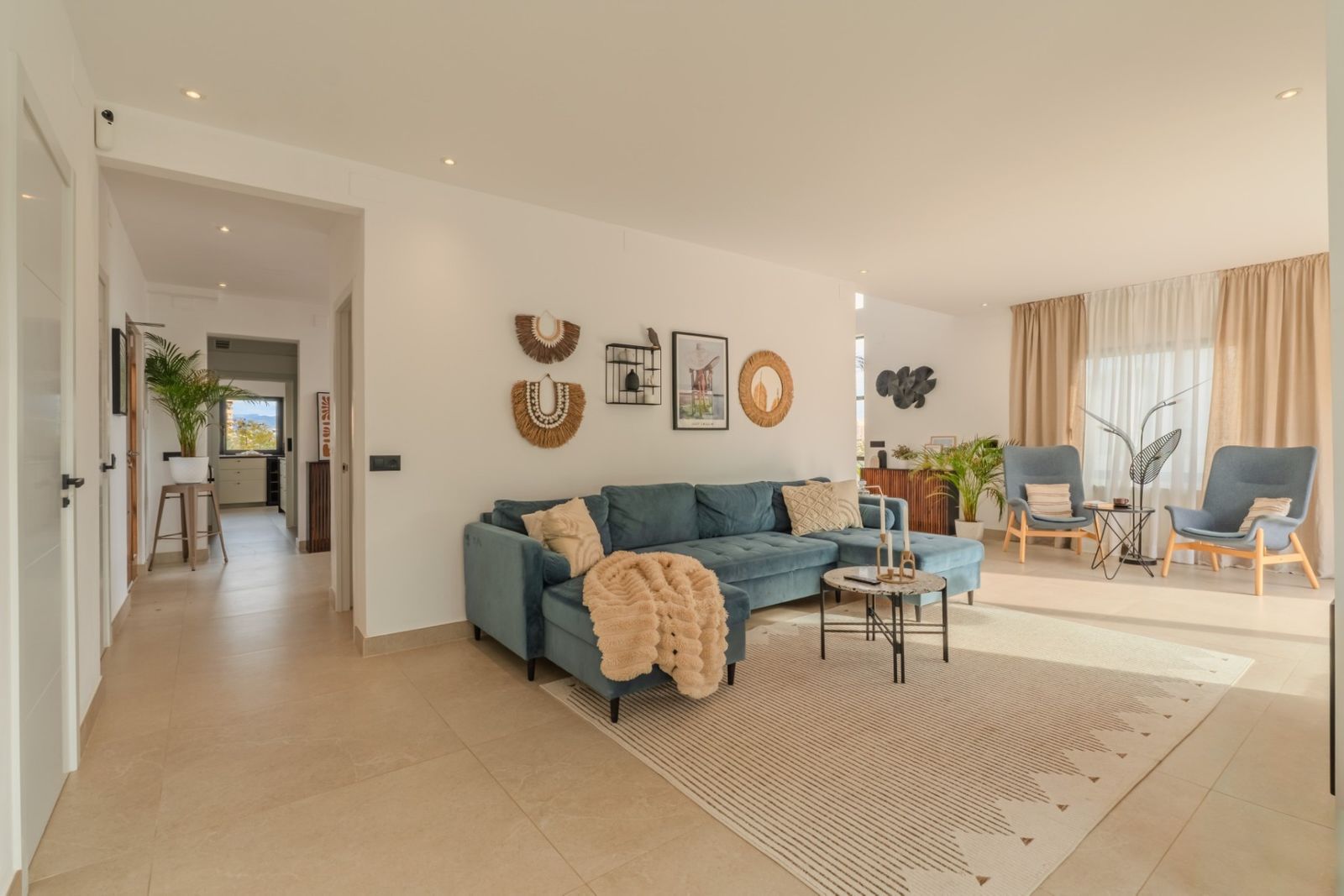 Modern woonkamer interieur met blauwe bank en decoratieve elementen.