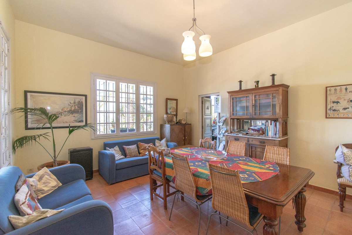 Gezellige woon- en eetkamer met blauwe banken en houten meubels.