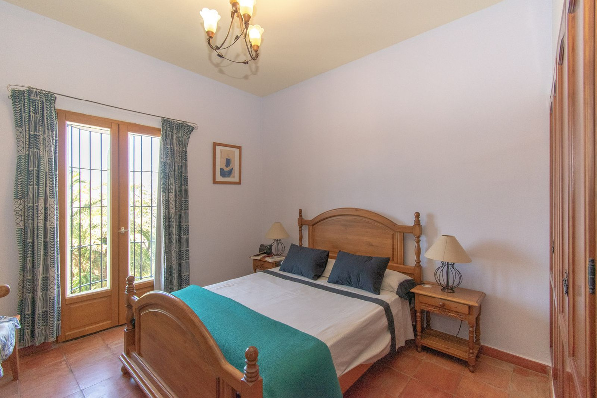 Gezellige slaapkamer met houten bed, nachtkastjes en groene accenten.