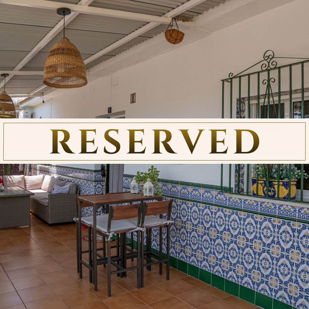 Covered terrace with bar seating, lounge area, and traditional tiled wall. Perfect for outdoor relaxation.