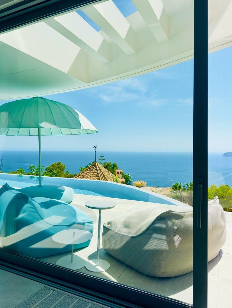 Modern living room with ocean view, bean bags, and outdoor seating