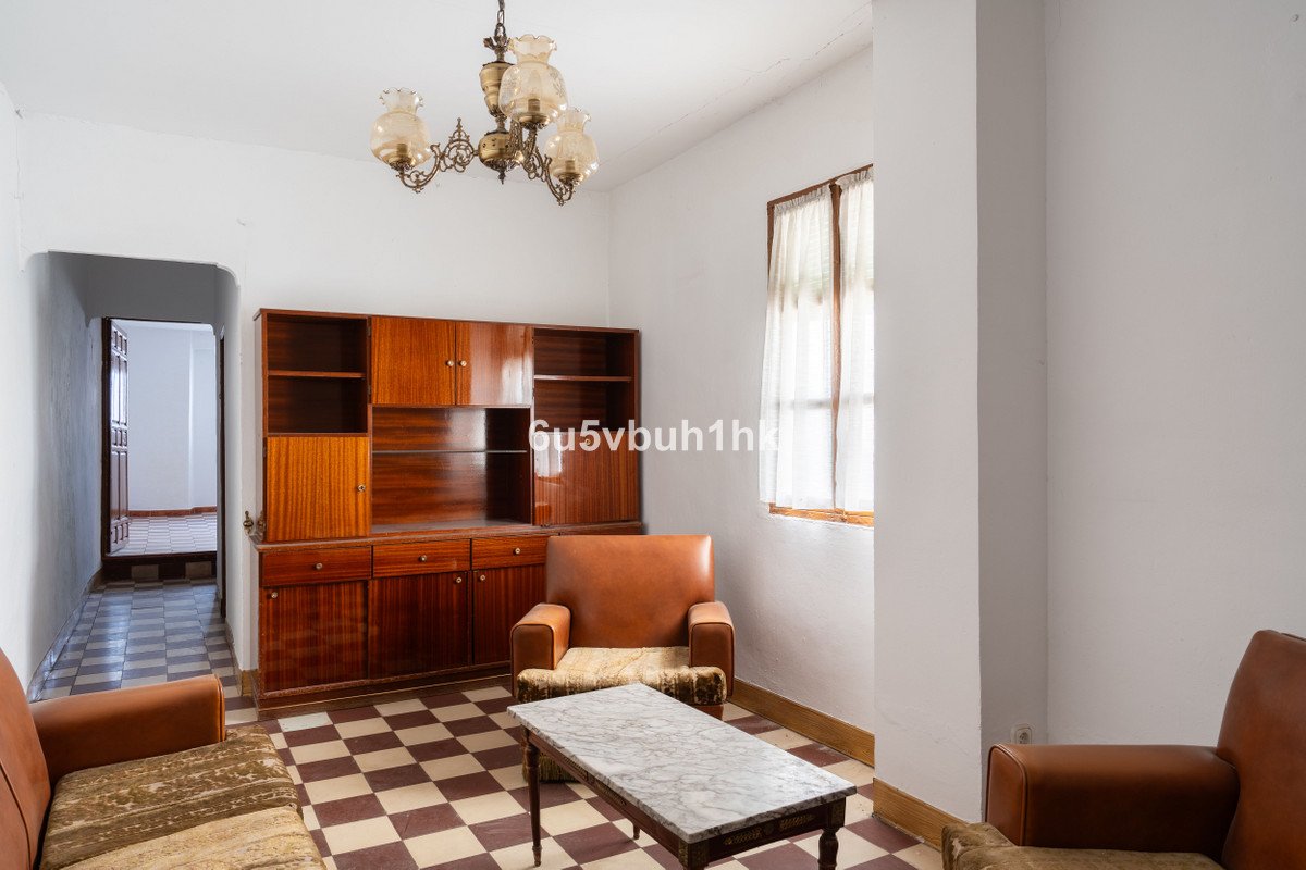 Living room with checkered floor, wooden furniture, and large window.