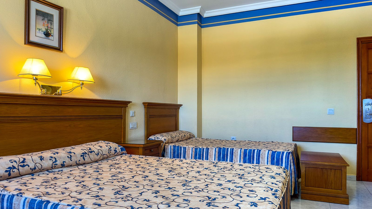 Gezellige hotelkamer met twee eenpersoonsbedden en houten meubels