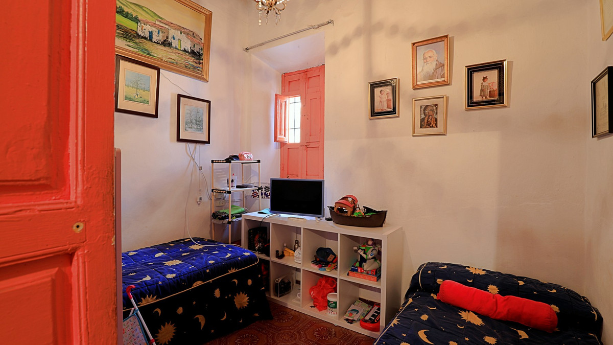 Eclectische slaapkamer met twee bedden en kleurrijke decoratie.