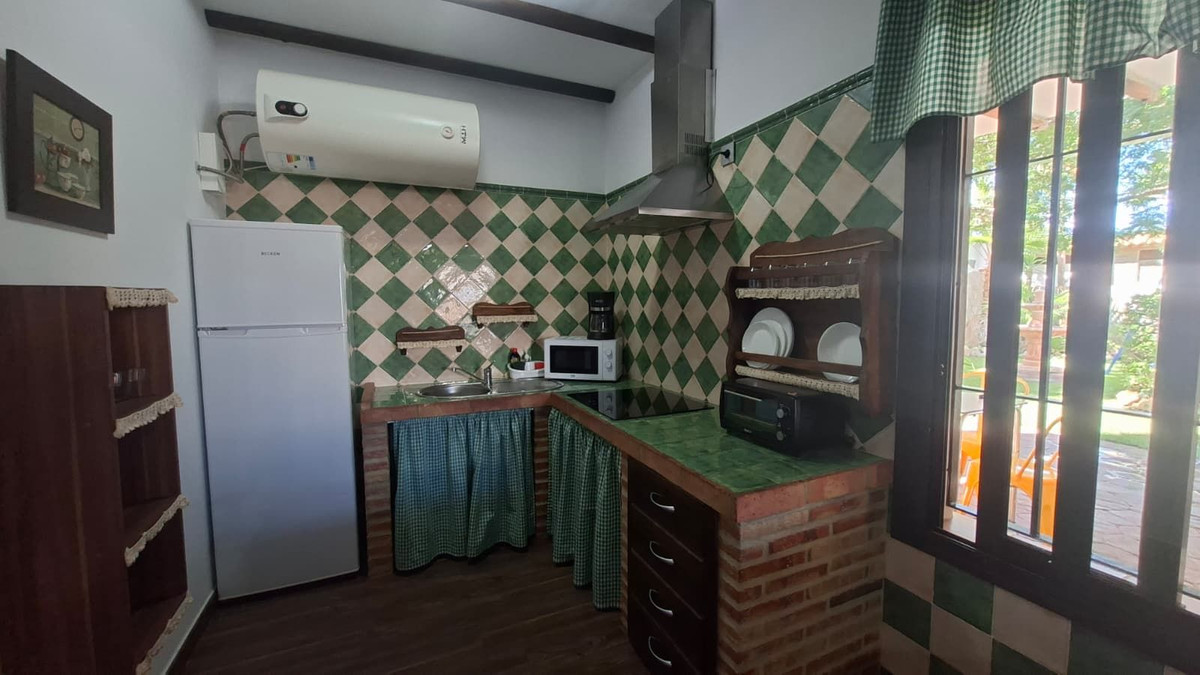 Rustieke keuken met groen-wit geblokte tegels en houten accenten.