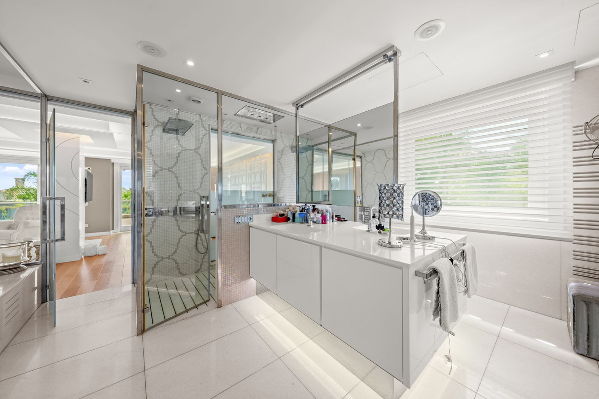 Moderne badkamer met glazen douchecabine en witte inrichting