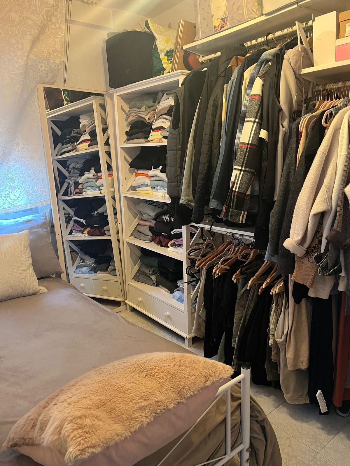 Slaapkamer met open kasten en georganiseerde kleding