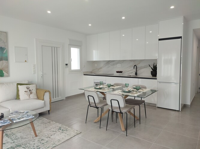 Modern appartement met witte keuken en eethoek