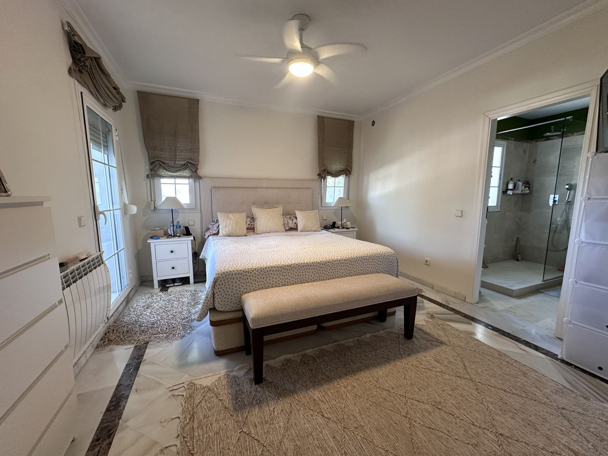 Slaapkamer en badkamer suite interieur met bed, bank en douchecabine.