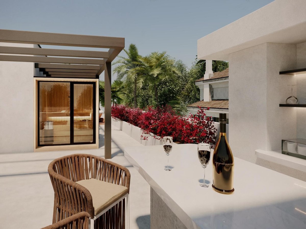 An outdoor bar area with glasses and a bottle of wine, next to a sauna and lush greenery.