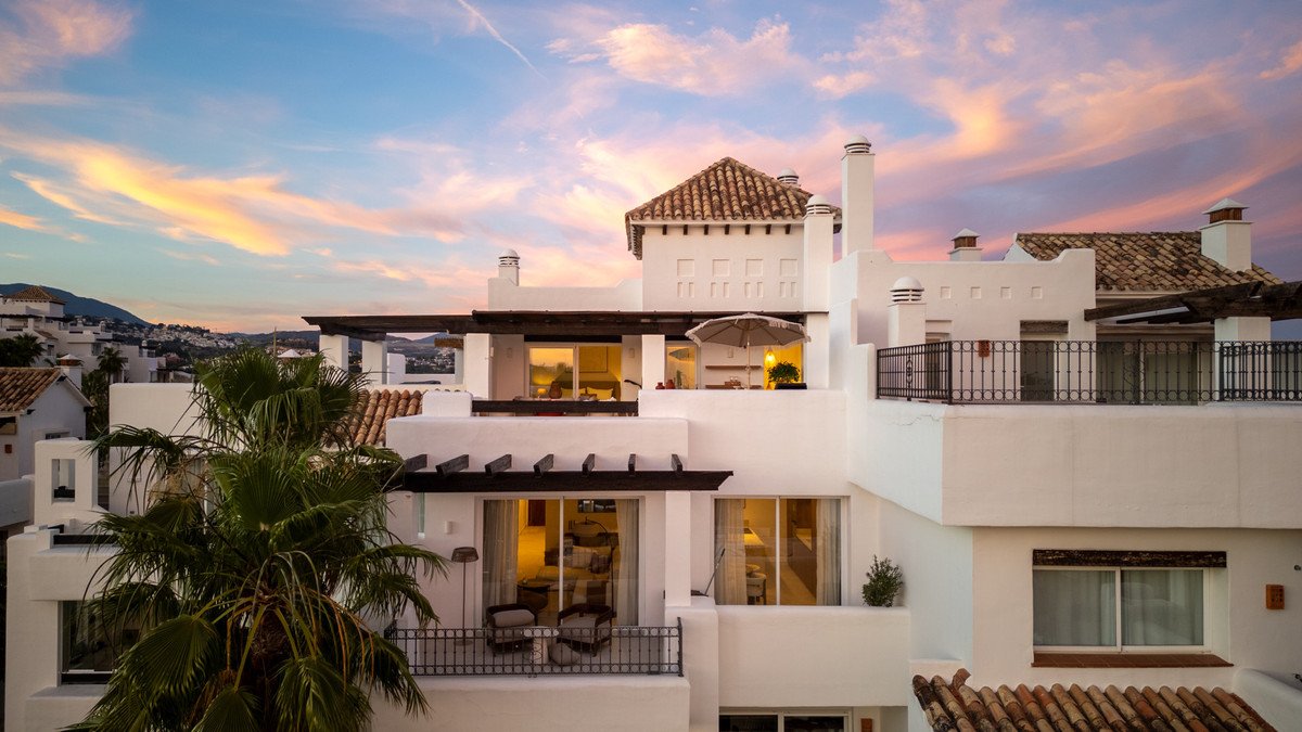 White two-story house with terracotta roof and sunset view