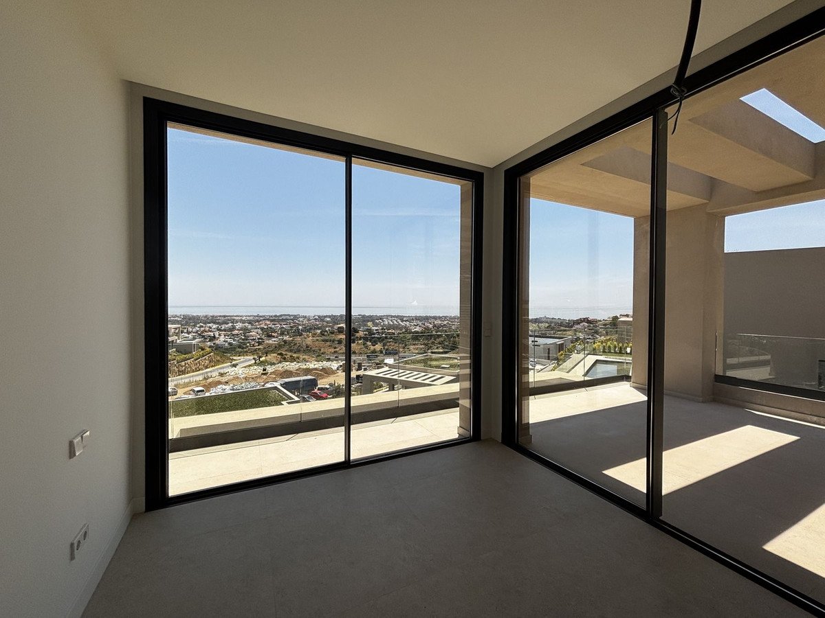 Spacious room with large windows overlooking the ocean and cityscape