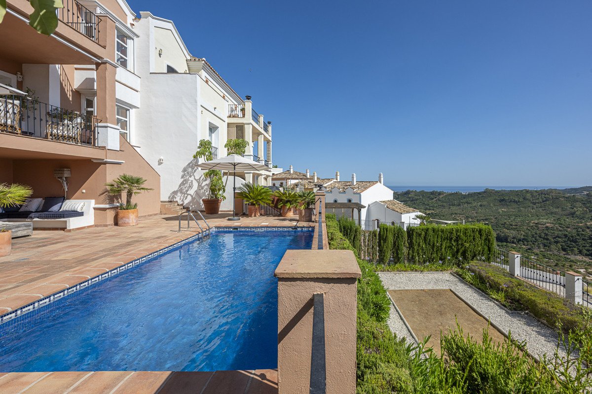 Swimming pool with loungers overlooking the sea and greenery