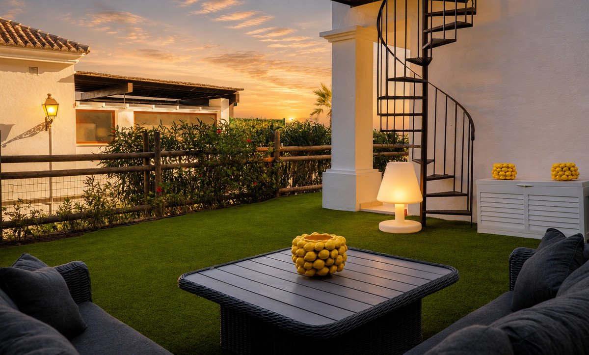 Sunset outdoor lounge with lush green lawn and decorative yellow centerpiece