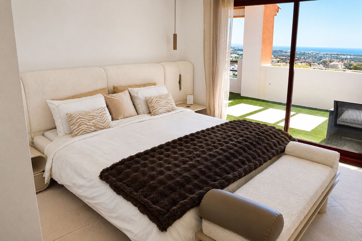 Bedroom with large bed, coastal view, and modern decor