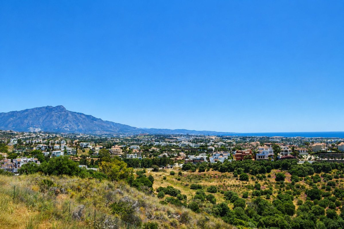 Panoramic view of a coastal town with mountains in the distance