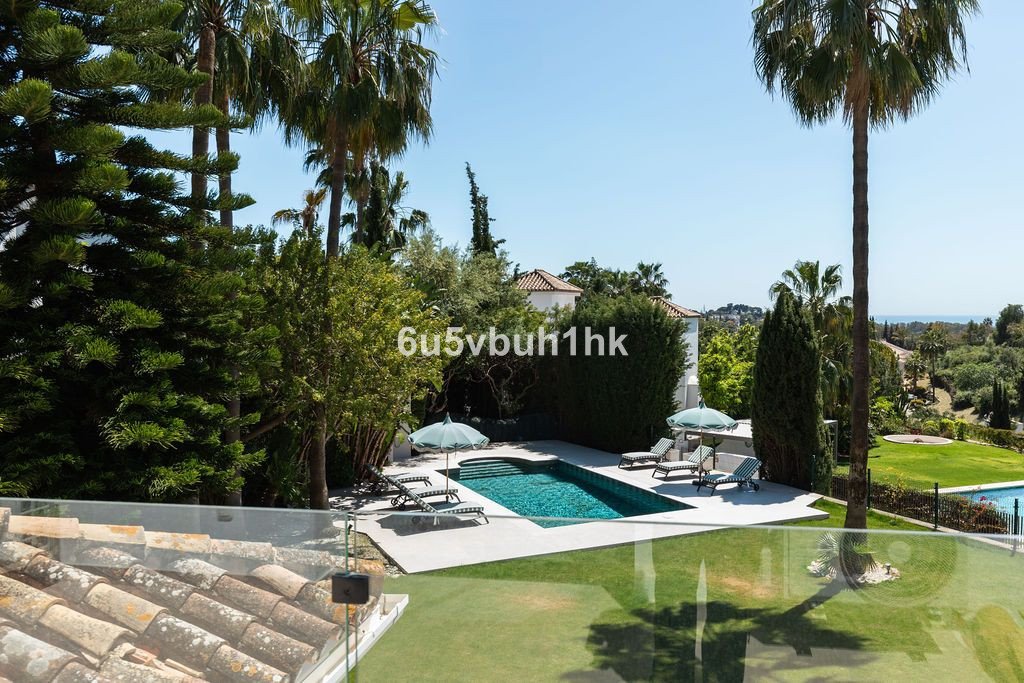 Luxurious swimming pool surrounded by lush garden and palm trees