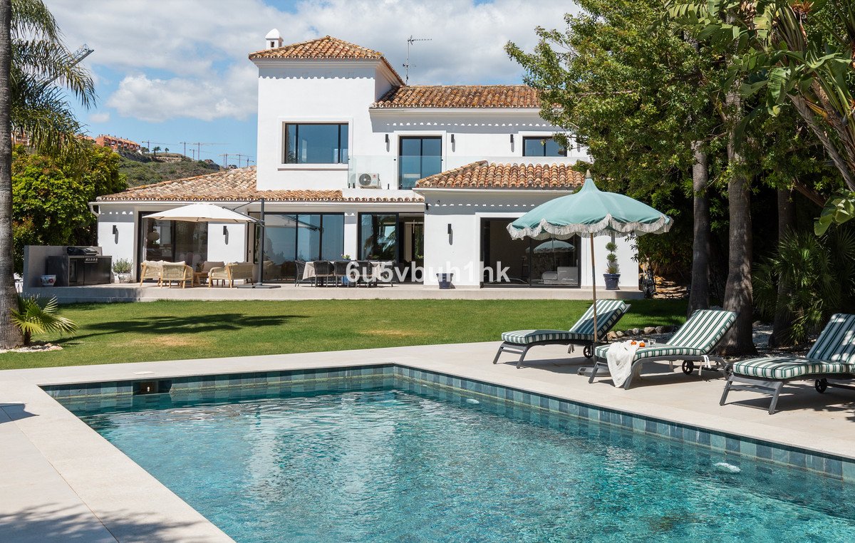 Modern two-story house with terracotta roof, swimming pool, and outdoor seating area
