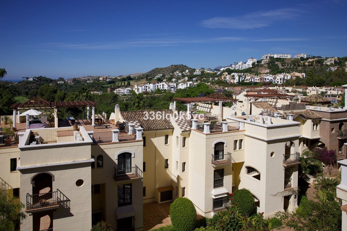Apartments with terraces offering panoramic views of rolling hills and a clear blue sky.