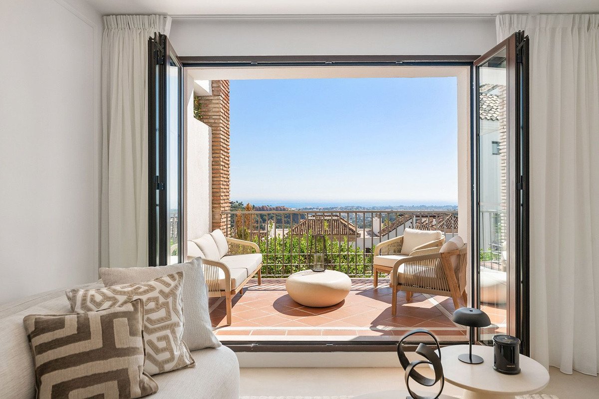 Living room with sliding doors opening to a balcony with sea view