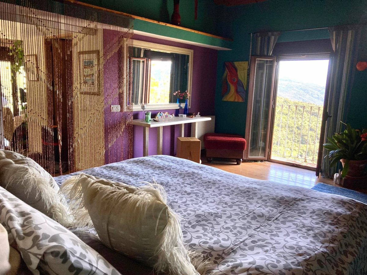 Eclectische slaapkamer met uitzicht op de bergen.