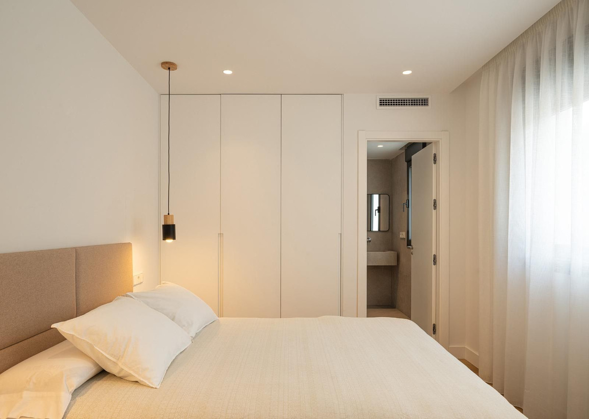 Moderne slaapkamer met ensuite badkamer en witte kledingkast.