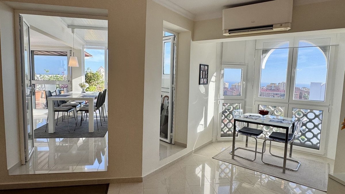 Two dining areas with modern furniture, featuring large windows with sea views and natural light.