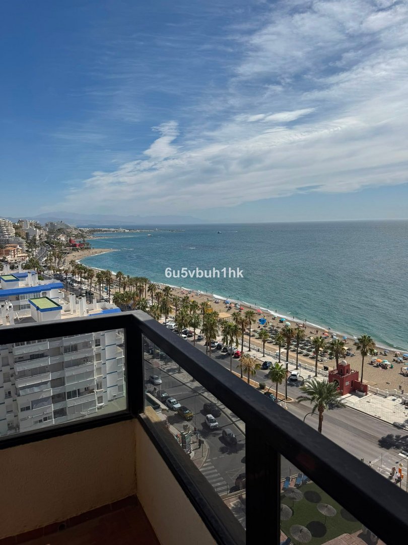 Balcony with ocean view, beachfront, and palm trees along the promenade.