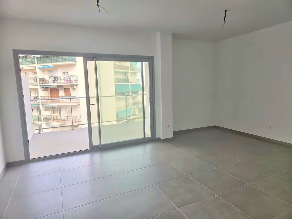 Empty living room with sliding glass doors leading to a balcony