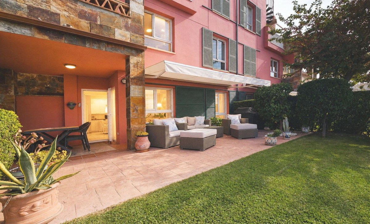 Pink house terrace with outdoor seating and greenery
