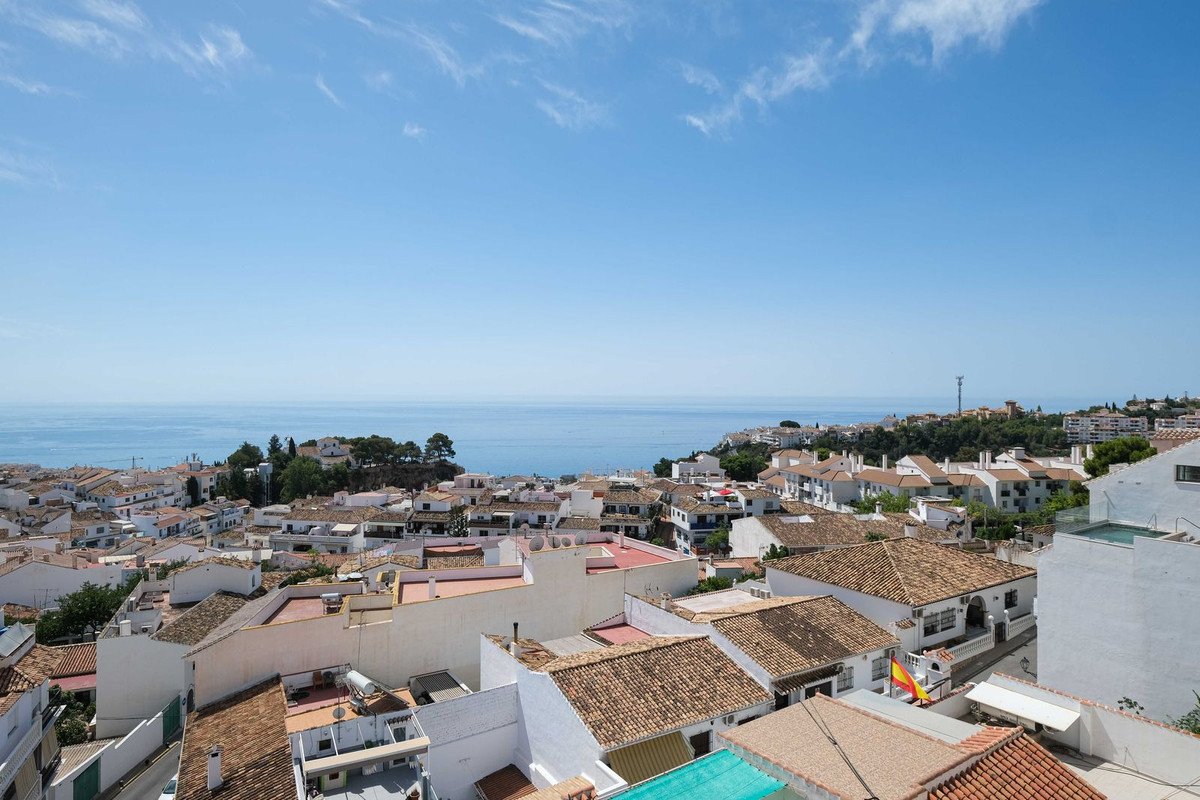 White-walled town rooftops with terracotta tiles overlooking the sea