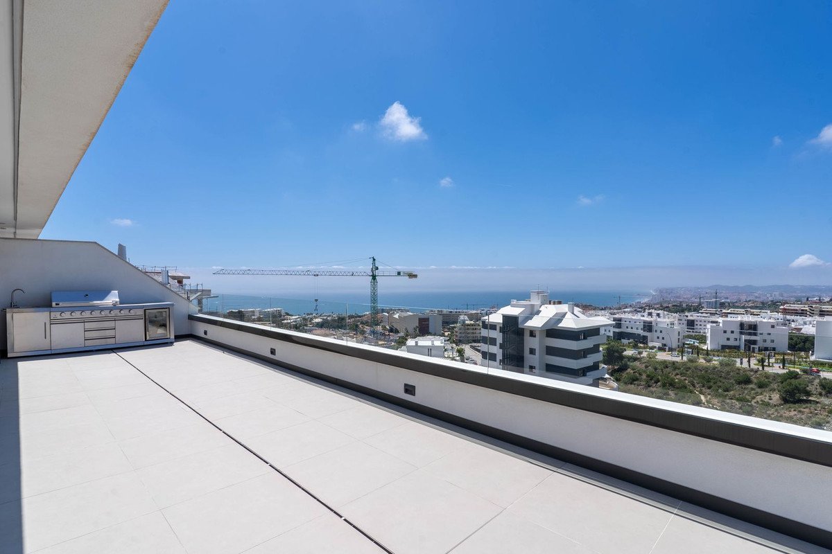 Rooftop terrace with sea view, outdoor kitchen, and cityscape.