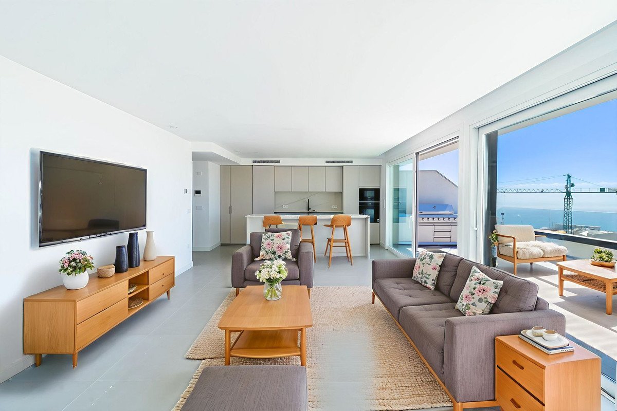 Modern living room with ocean view, open-plan layout, and large sliding glass doors