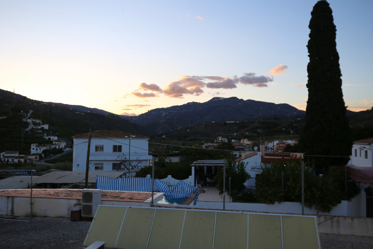 Uitzicht op bergen en villa bij zonsondergang