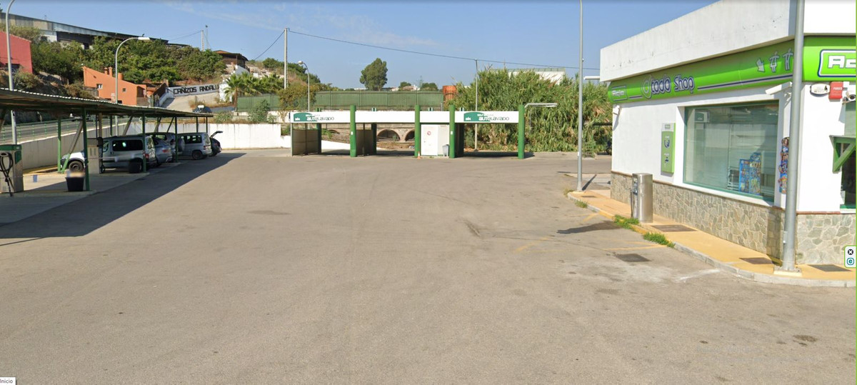 Buiten autowasstraat met overdekte wasplaatsen en shop.