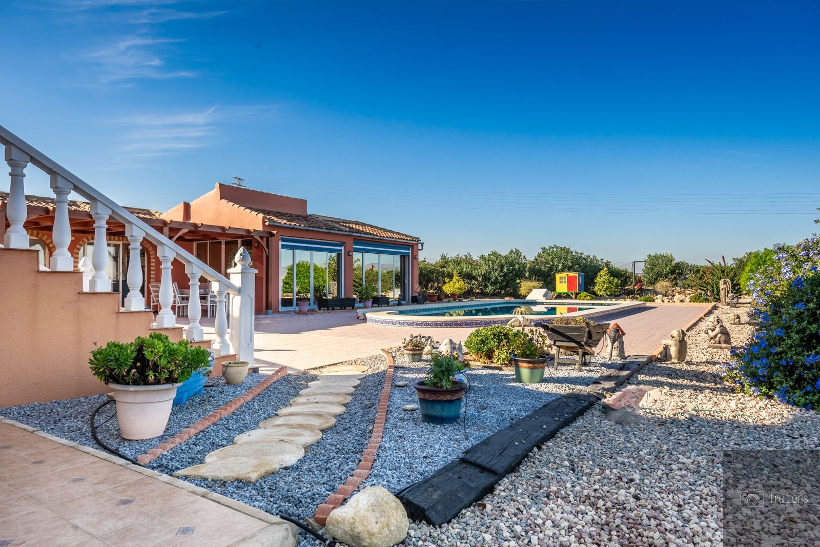 Luxe villa met tuin en zwembad op een zonnige dag.