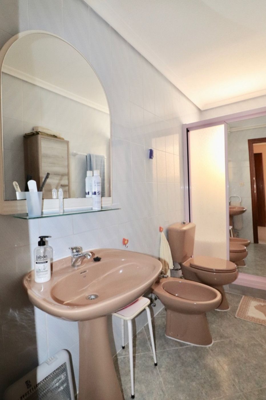 Roze badkamer met wastafel, bidet, toilet en spiegel