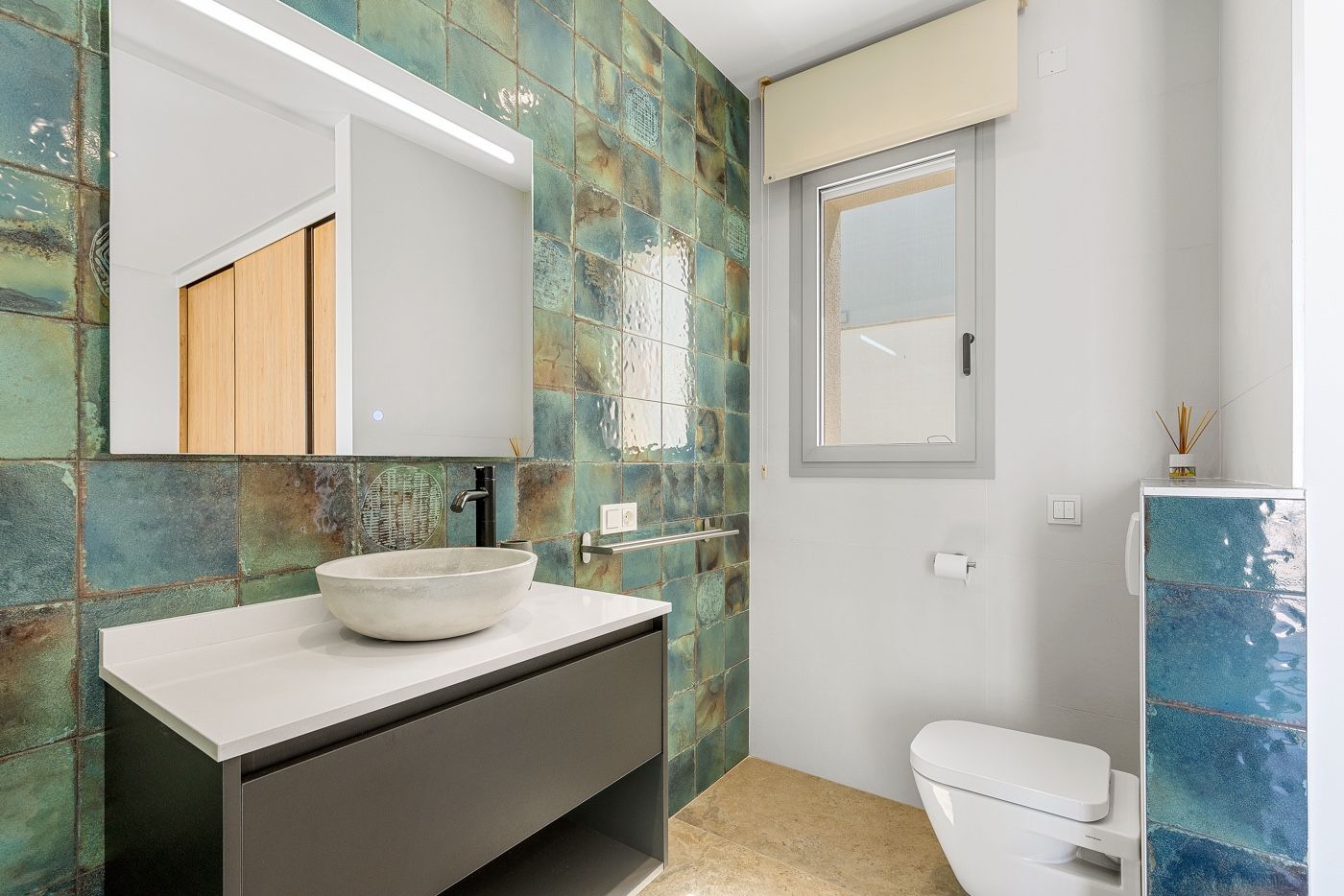 Stijlvolle badkamer met turquoise tegels en modern wastafelmeubel