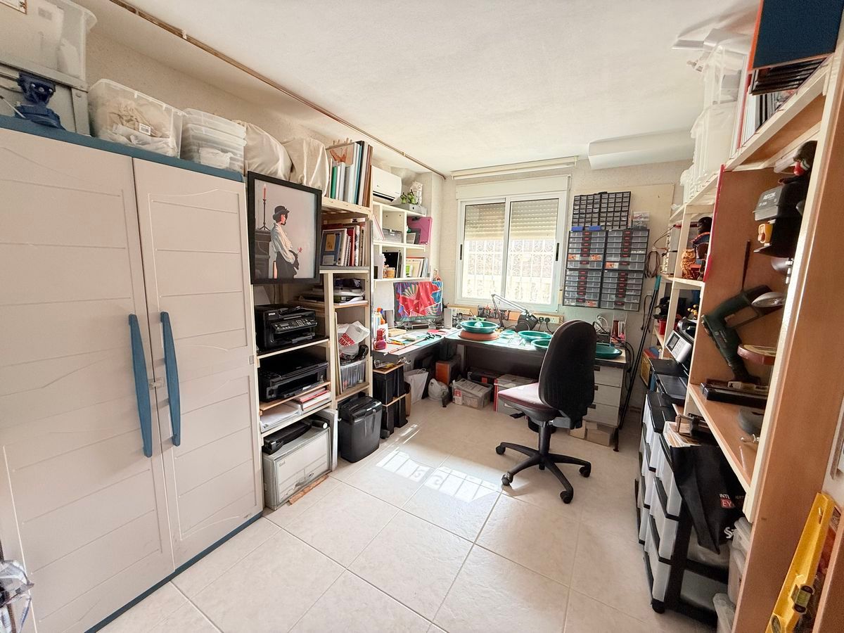 Georganiseerde hobbykamer met veel opbergruimte en een bureau