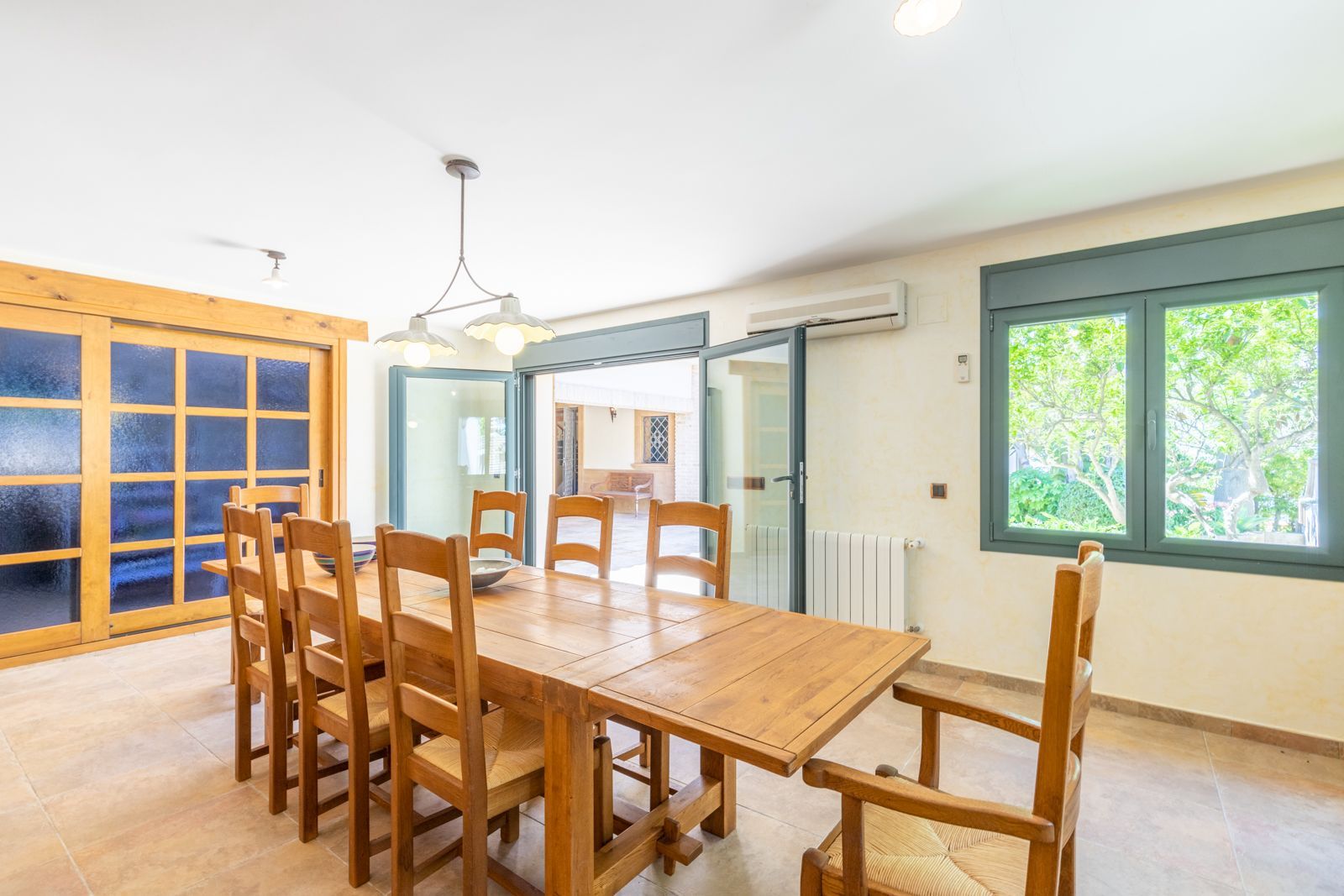 Houten eettafel met stoelen in een lichte eetkamer.