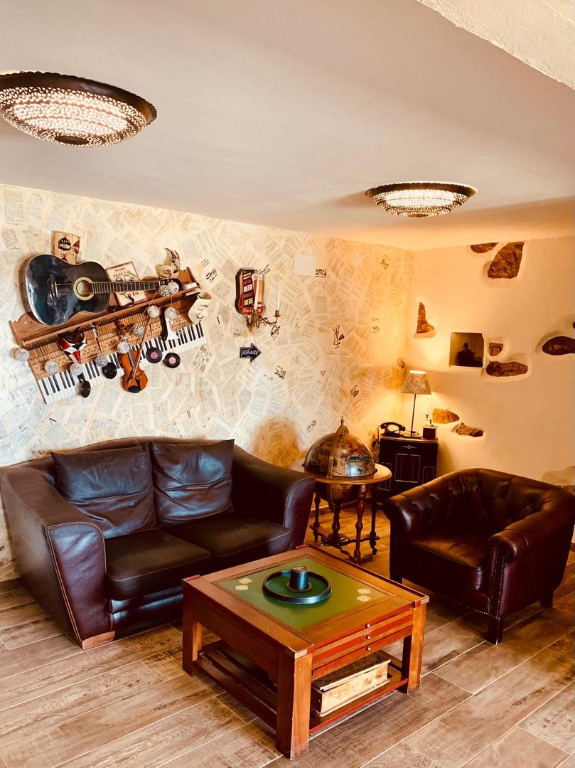 Cozy living room with leather sofas, music-themed decor, and vintage chandeliers