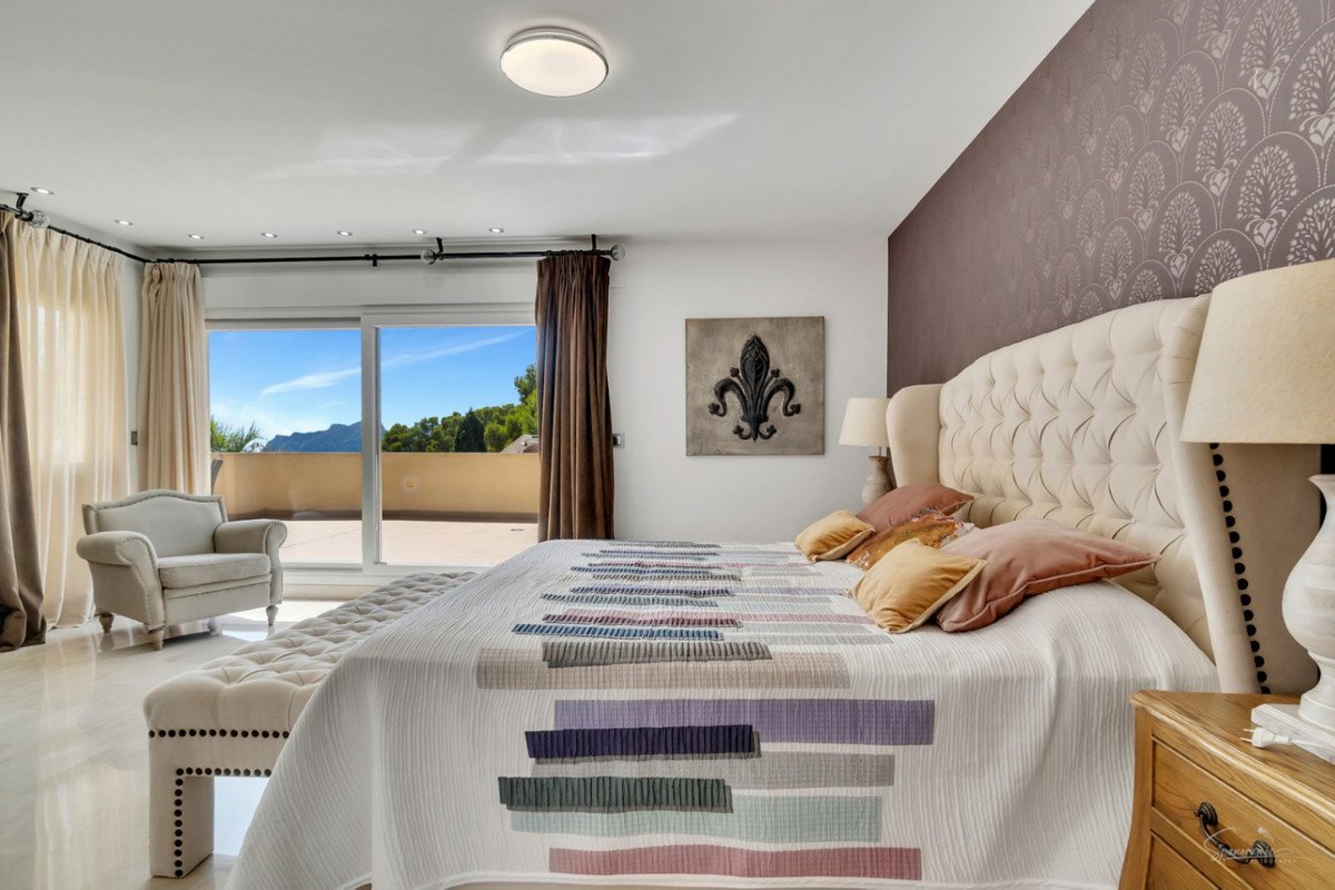 Luxurious master bedroom with large windows overlooking the sea