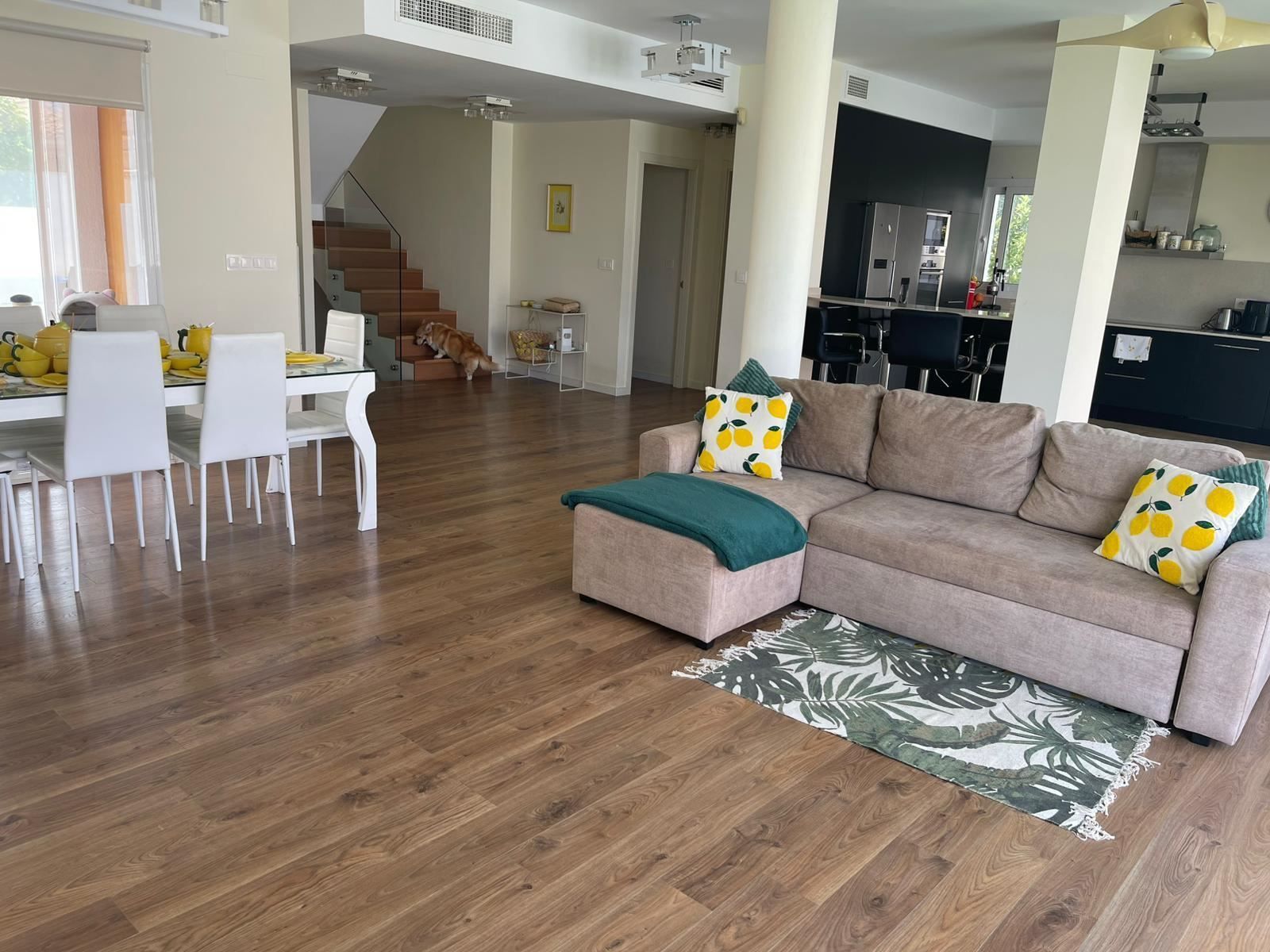 Ruime, moderne open woonkamer met eethoek en keuken.